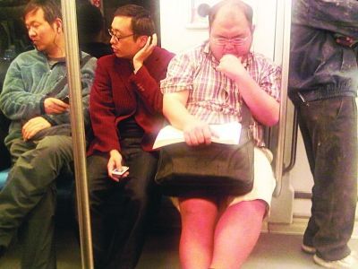 “短裤哥”在地铁上看书很用功。